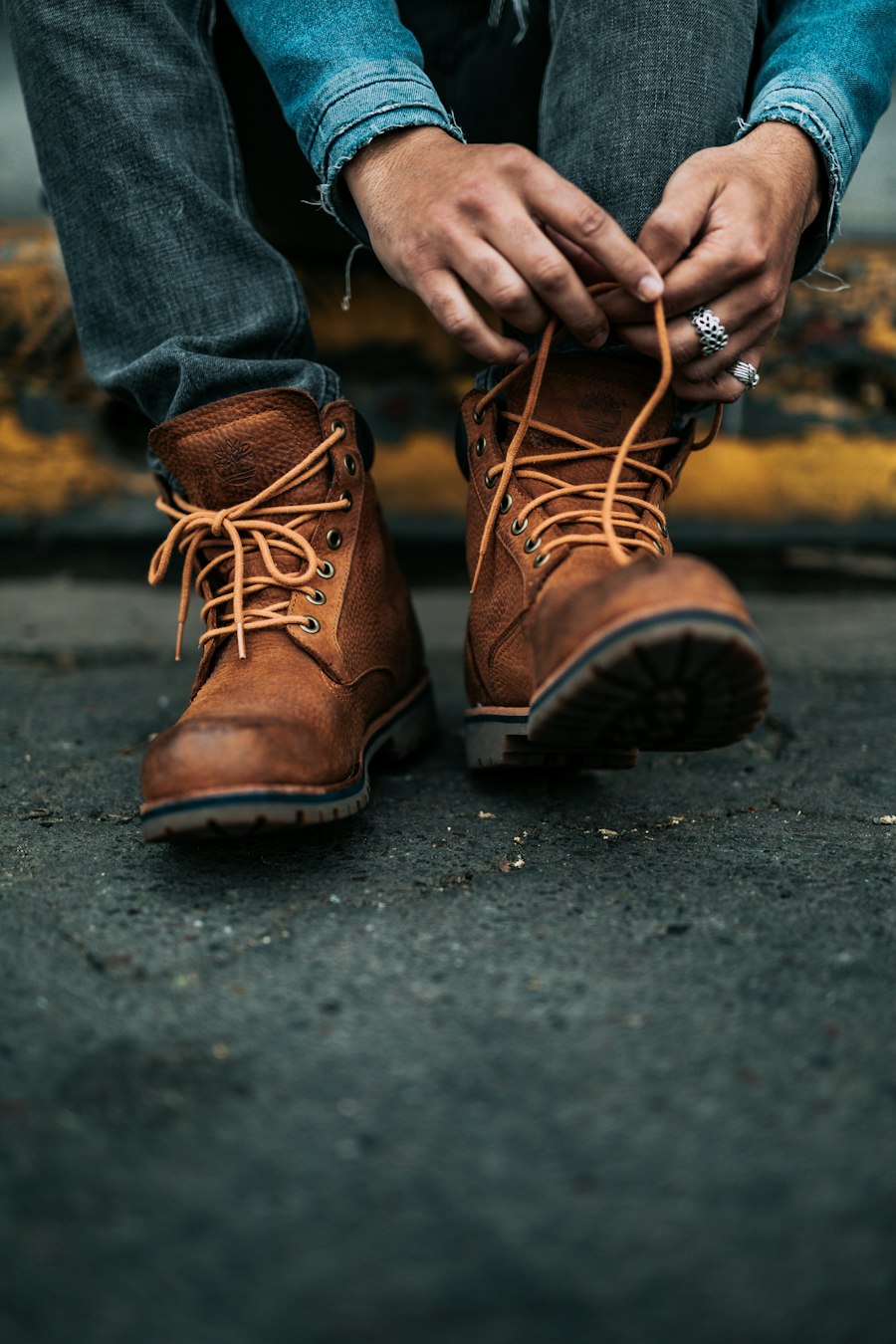 Brown nubuck lace-up boots being tied