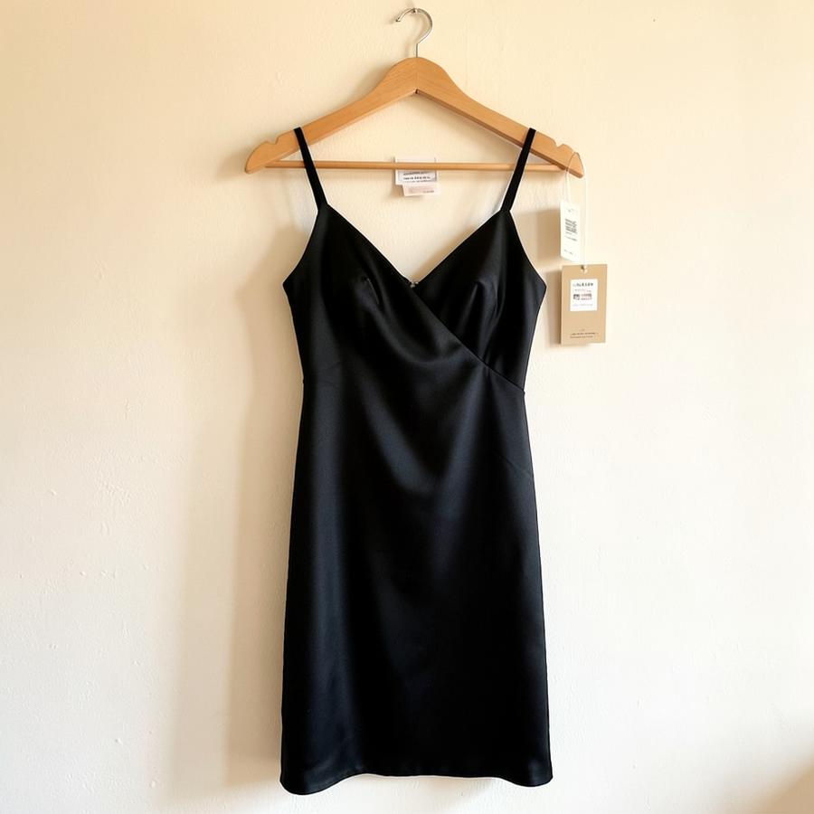 Black midi slip dress on a wooden hanger